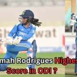 Jemimah Rodrigues playing a cricket shot and raising her bat to celebrate her highest ODI score of 123 runs, wearing the Indian women's cricket team blue jersey.