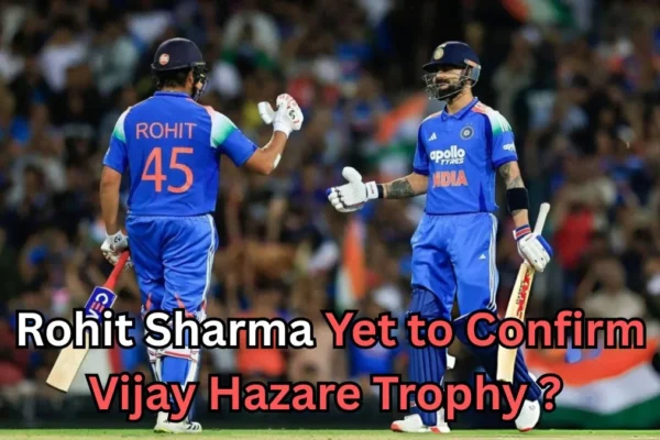 Two Indian cricket players wearing blue jerseys on the field, giving each other a fist bump during a match. The player on the left has 'Rohit 45' on his jersey. The text on the image reads ‘Rohit Sharma Yet to Confirm Vijay Hazare Trophy?