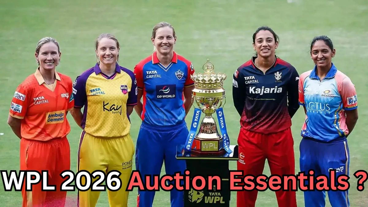 Six women cricketers from different WPL teams stand side by side on a cricket field, smiling and posing behind the Women’s Premier League trophy placed on a podium. They are wearing their respective team jerseys in colors like orange, yellow, blue, red, and light blue. Text at the bottom of the image reads: “WPL 2026 Auction Essentials?