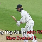 A New Zealand cricketer in white Test uniform plays a shot on the field as the red ball approaches. Text on the image reads ‘Conway Hay shine with fifties as New Zealand?