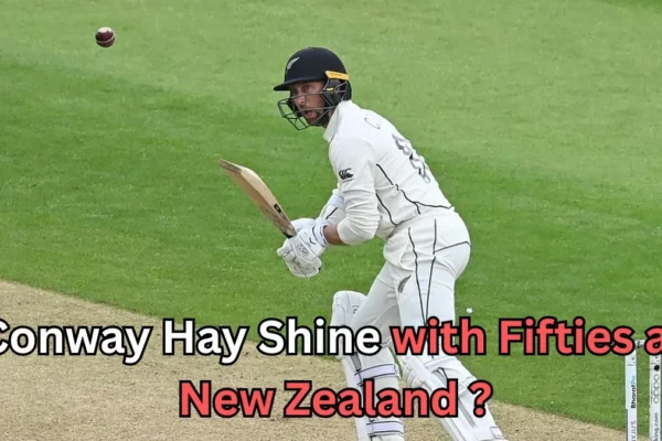 A New Zealand cricketer in white Test uniform plays a shot on the field as the red ball approaches. Text on the image reads ‘Conway Hay shine with fifties as New Zealand?