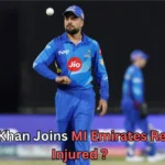 A male cricketer in a blue MI Emirates uniform is on the field, wearing a cap and looking focused while a cricket ball hovers above his hand. Another player in similar blue kit is blurred in the background. Text on the image reads: “Rashid Khan Joins MI Emirates Replaces Injured ?”