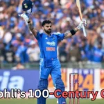 A cricketer in a blue uniform stands on the field holding his helmet in one hand and his bat raised in the other while facing a cheering crowd in the stadium. Stumps are visible behind him. Text at the bottom of the image reads “Virat Kohli’s 100-Century Quest?